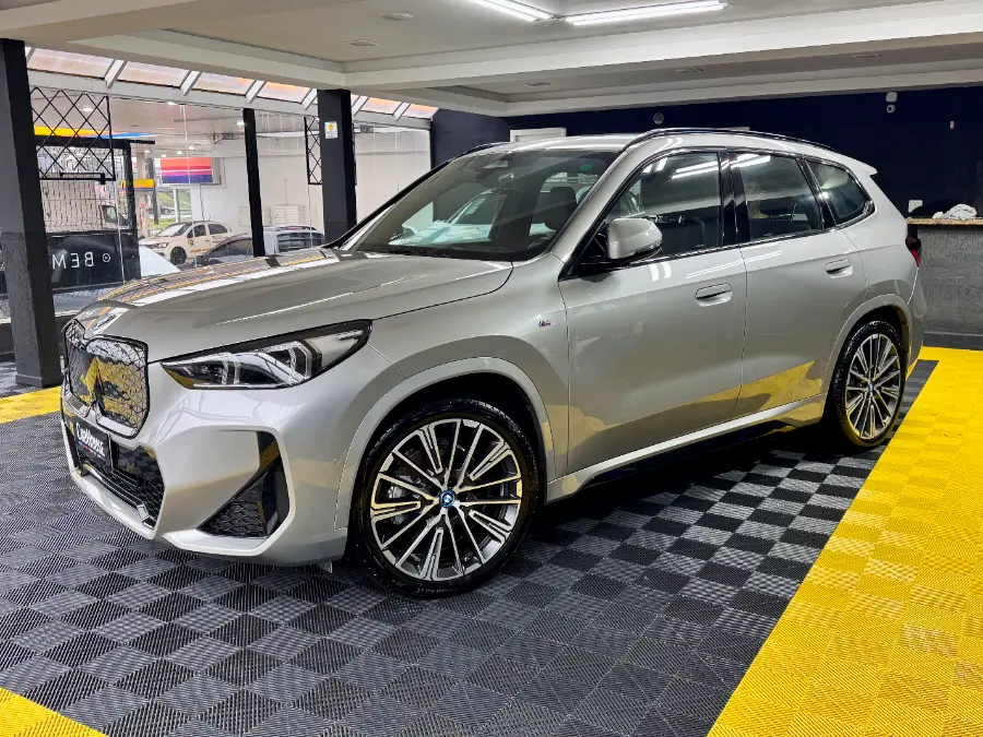 BMW iX1 M Sport cinza — frente no estúdio de detailing da CarHouse Curitiba